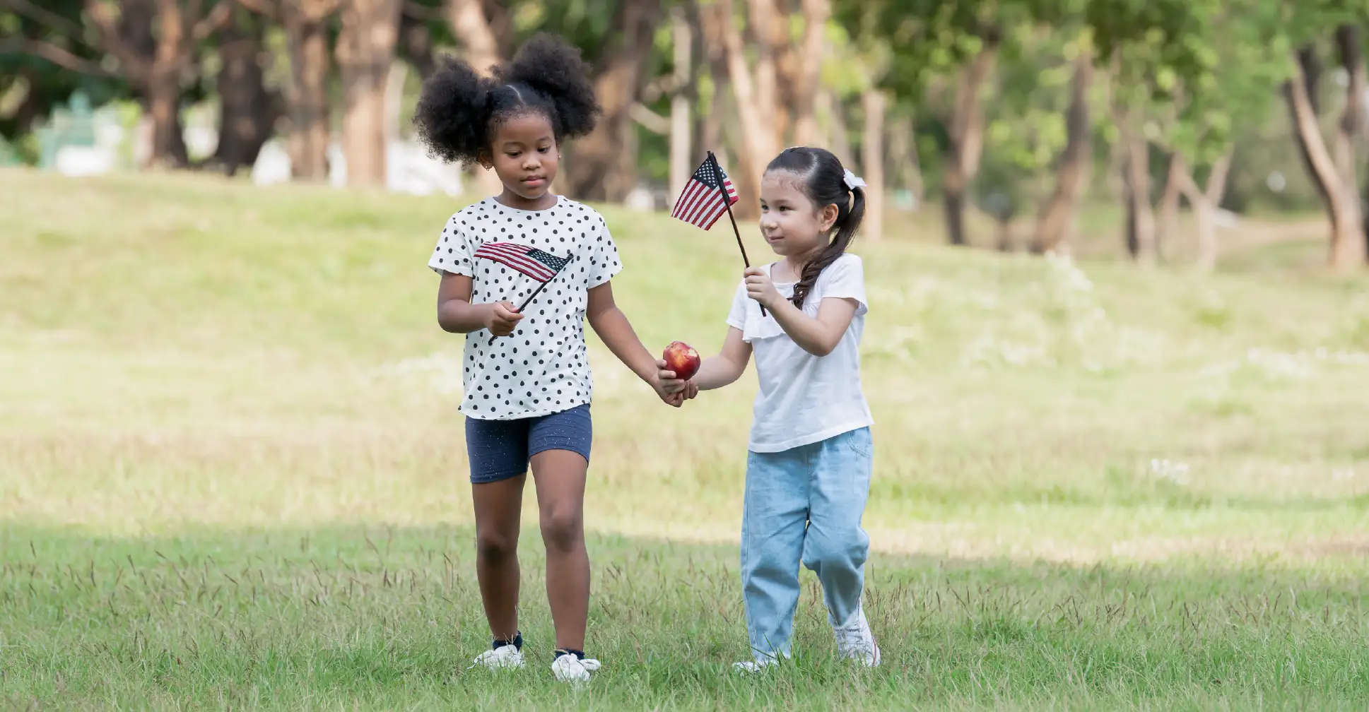 Kids walking with American flags celebrating Flag Day.