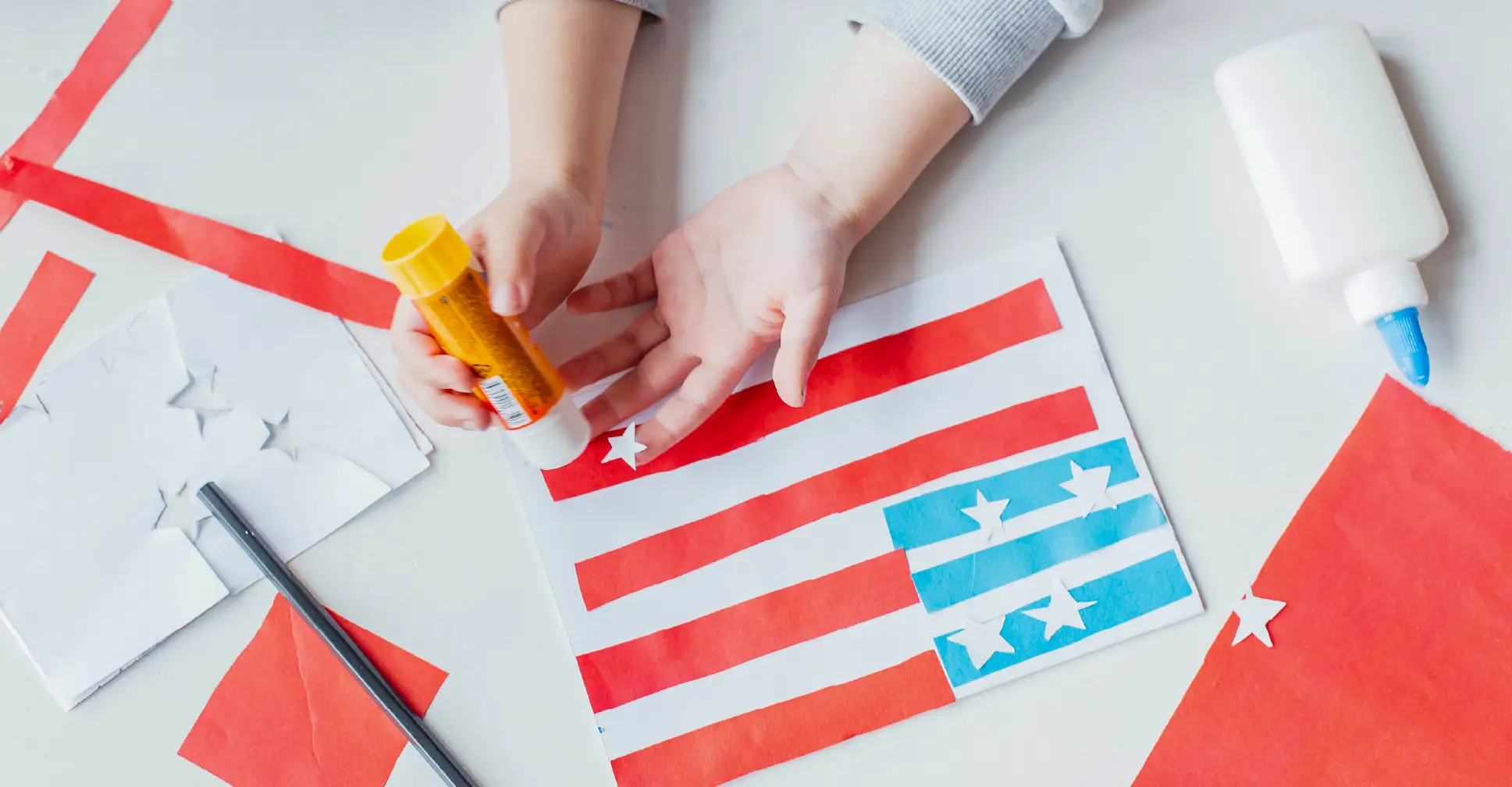 Preschool-aged kid making an American Flag as a craft for Flag Day.