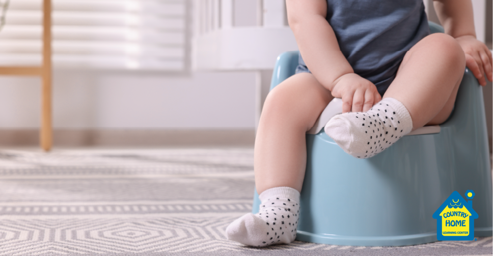 toddler being potty trained with a potty chair