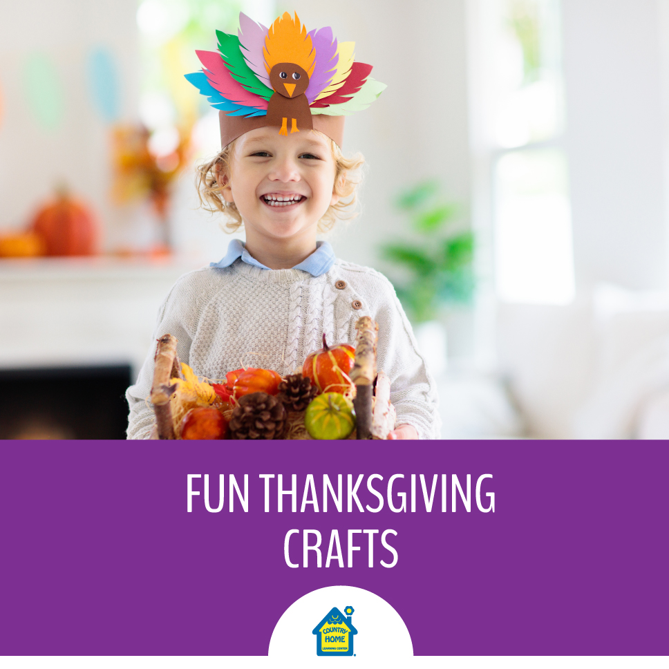 young boy wearing a construction paper turkey headband and carrying a thanksgiving basket