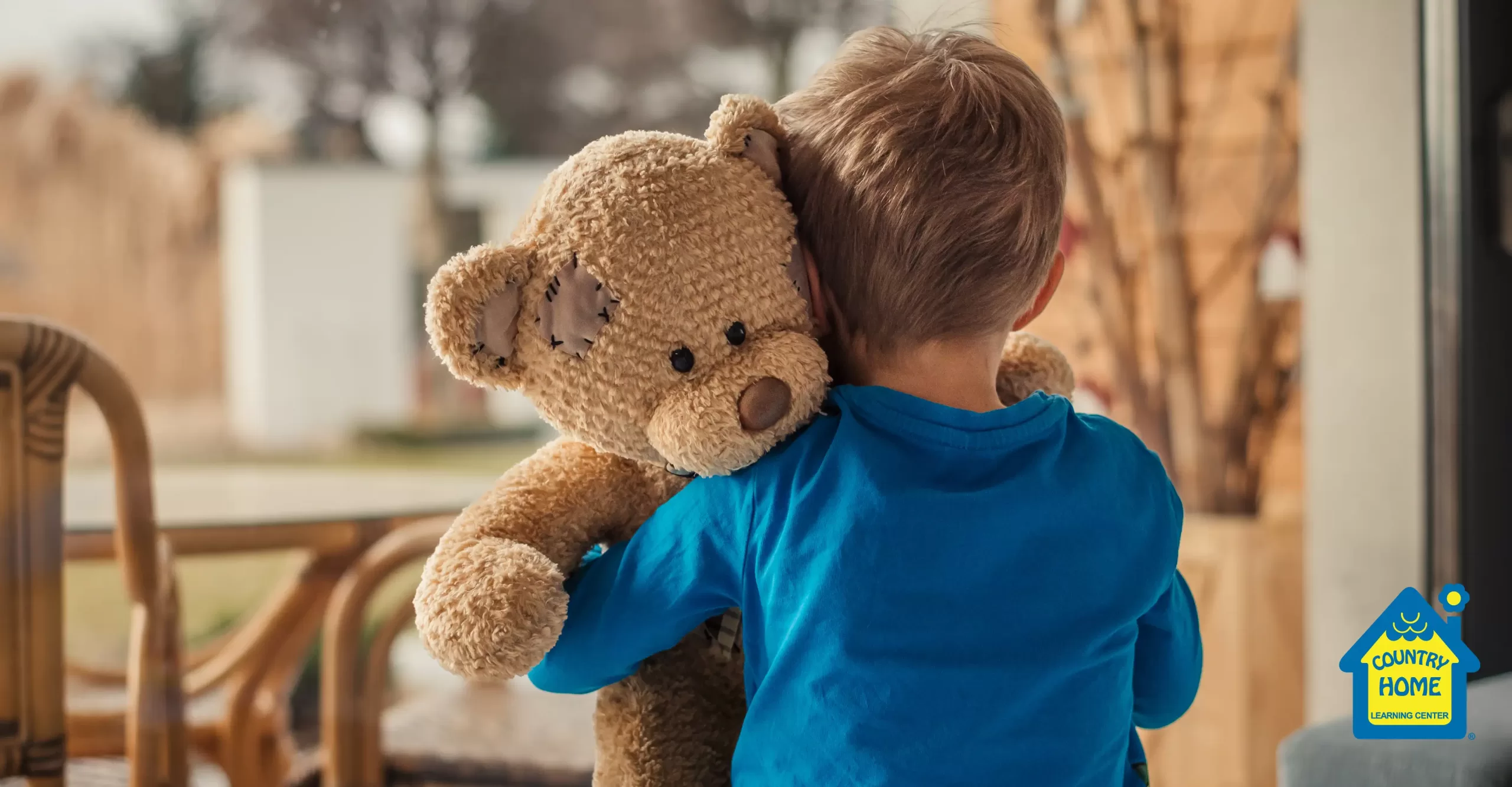 young boy expressing empathy and hugging his stuffed teddy bear
