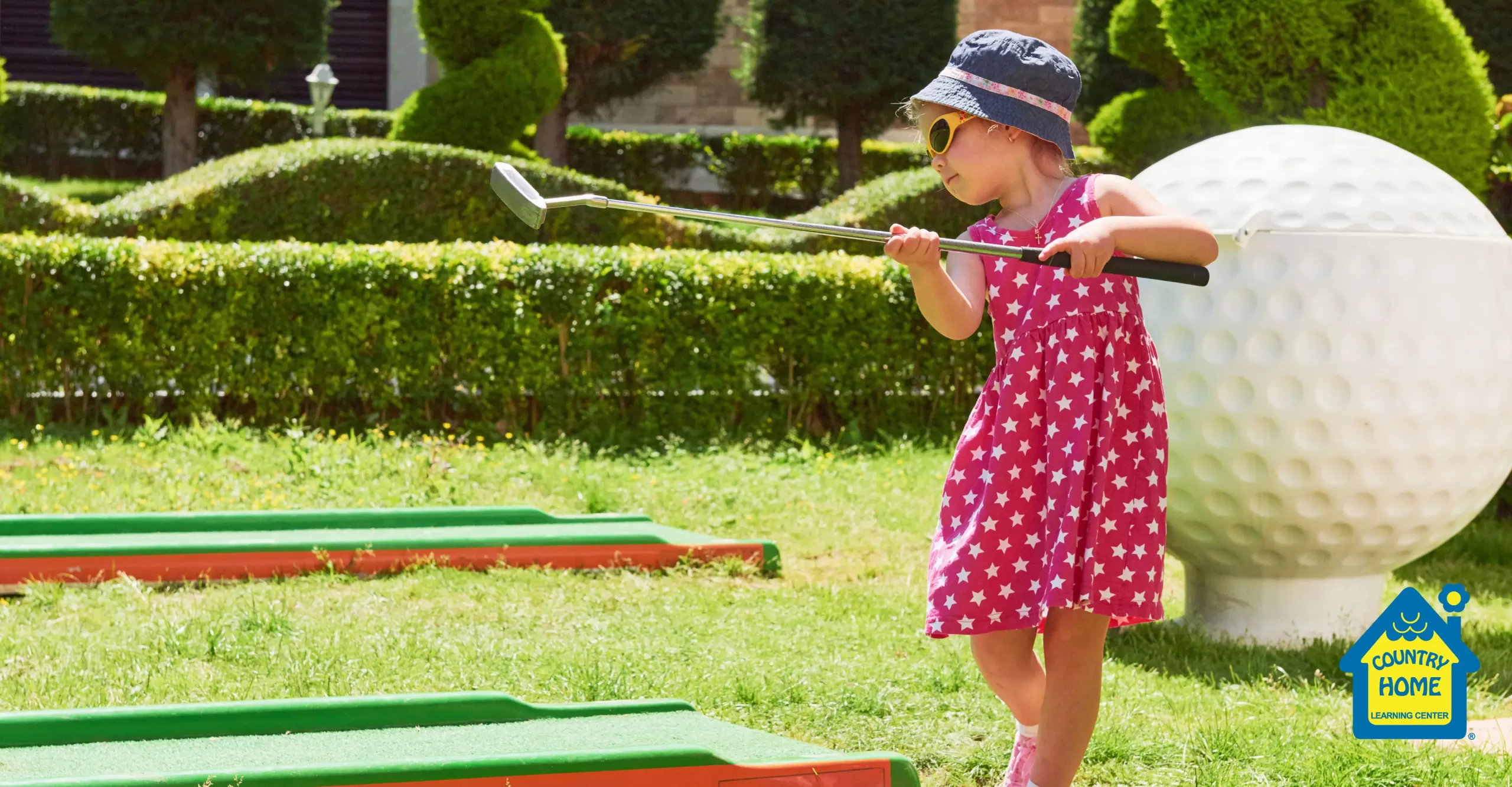 little girl learning hand eye coordination while playing mini golf