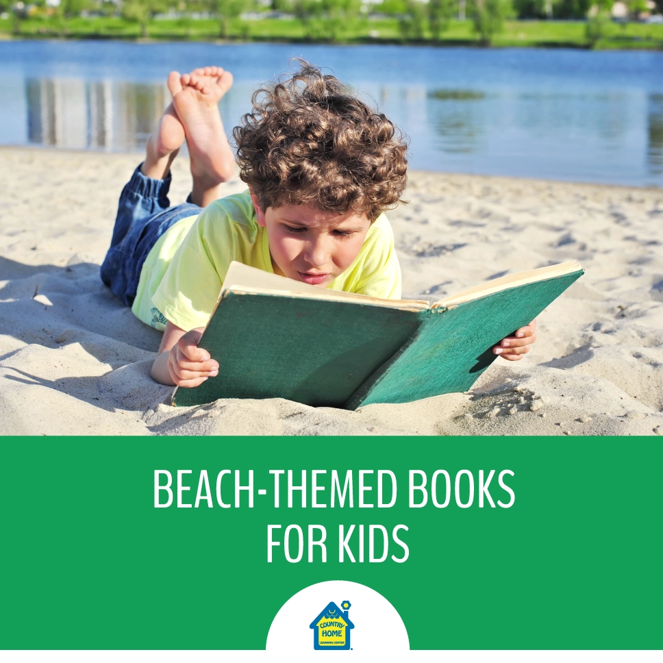 young boy reading a book on the beach