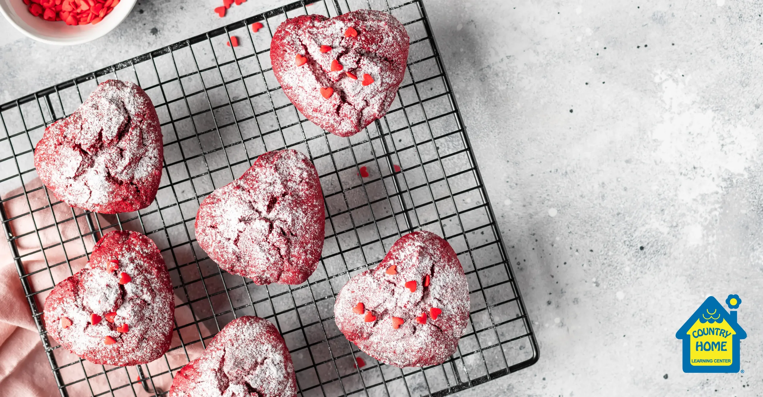 red heart shaped cupcakes with powered sugar on a cooling rack for Valentine's day