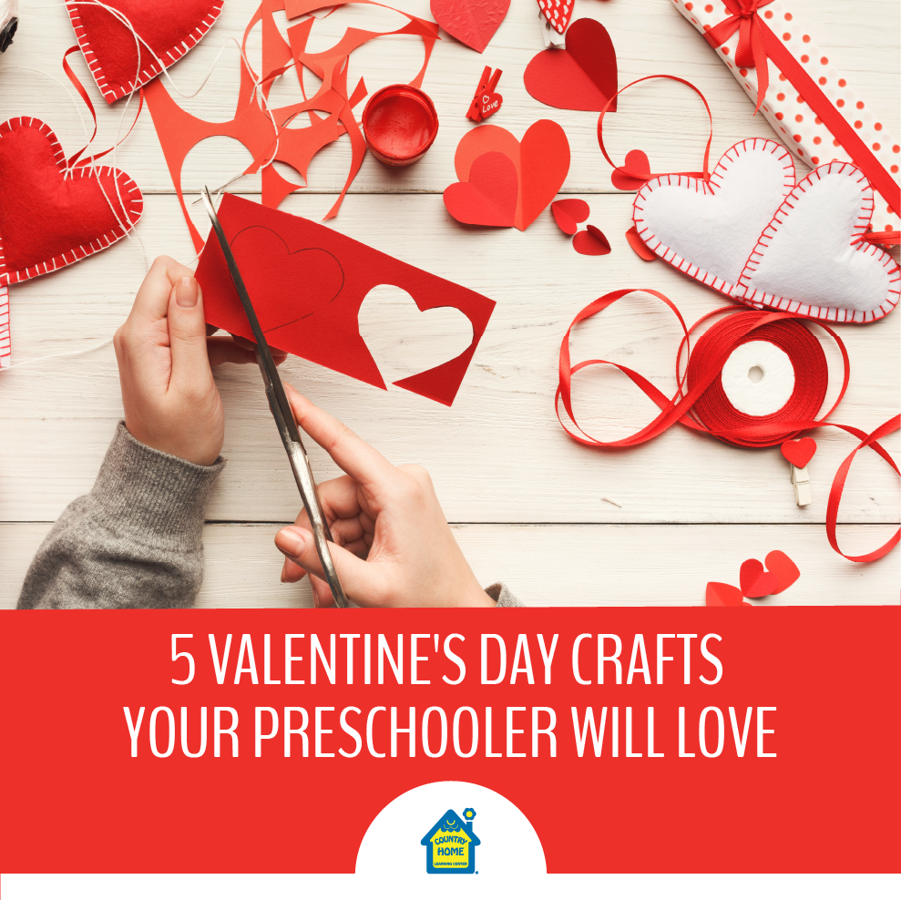 Hands cutting red paper hearts on a table with various Valentine’s Day crafts supplies, including ribbon, felt hearts, and scissors. Text: 5 Valentine's Day Crafts Your Preschooler Will Love.