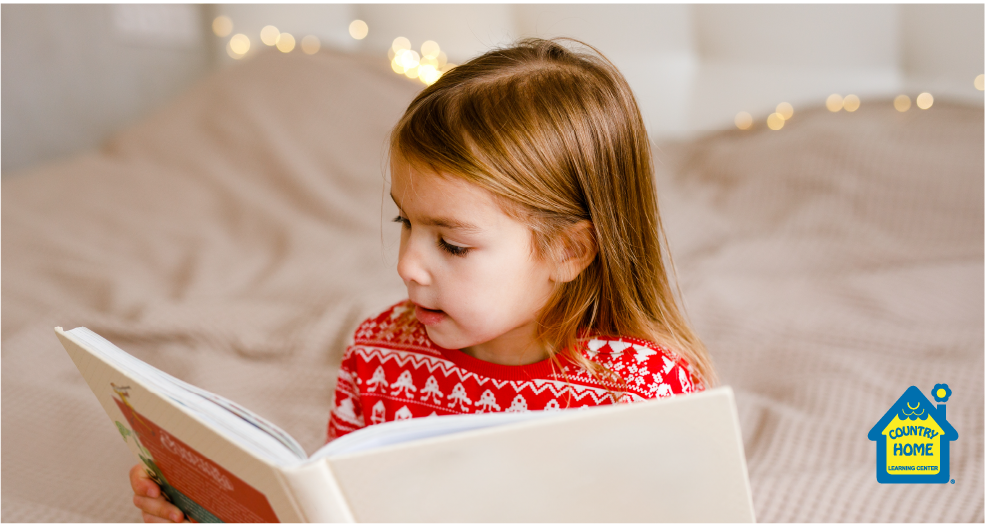 Young girl in Christmas sweater reading a children's book