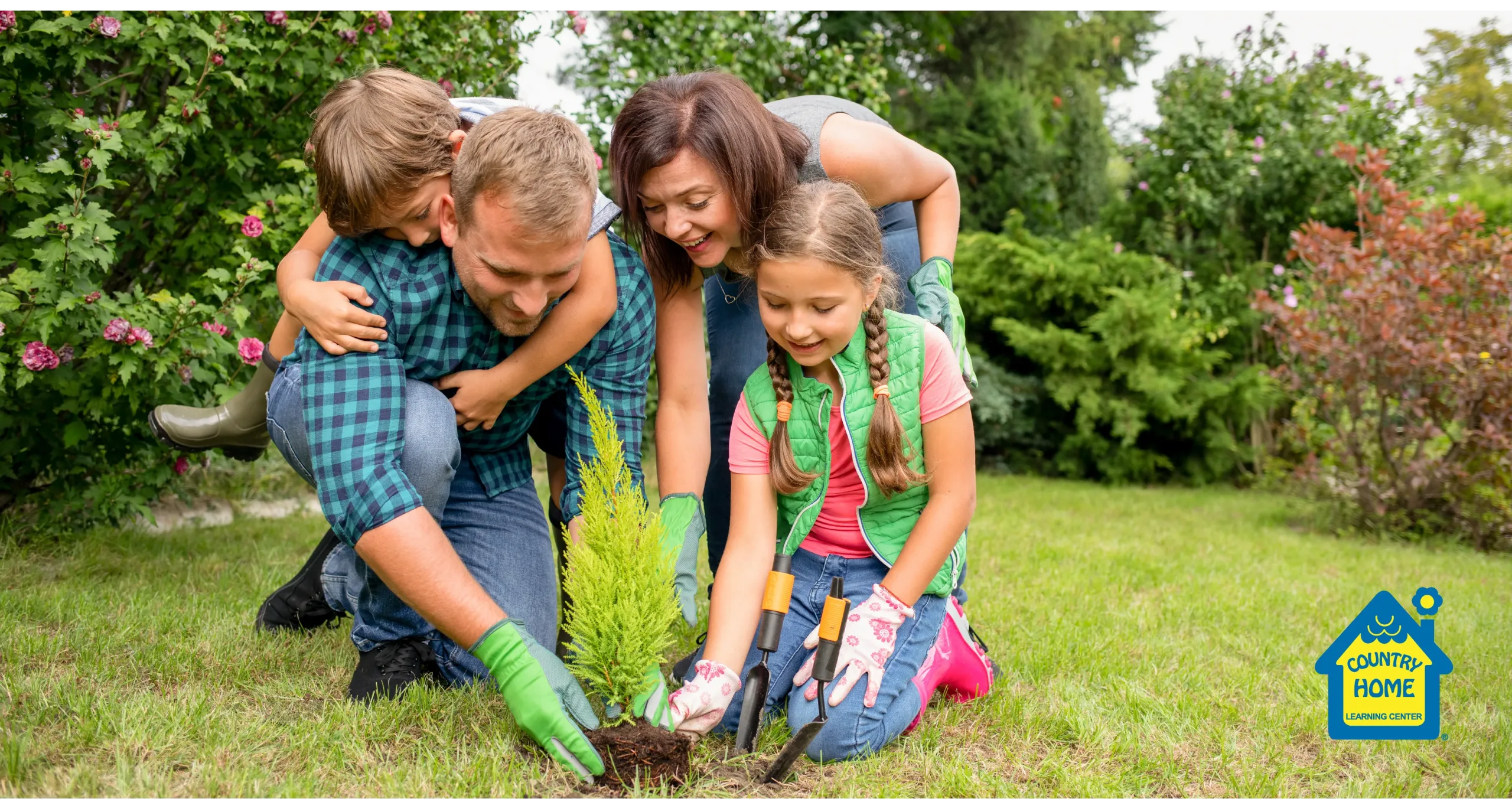 Family of 4 happily planting a tree for volunteer work