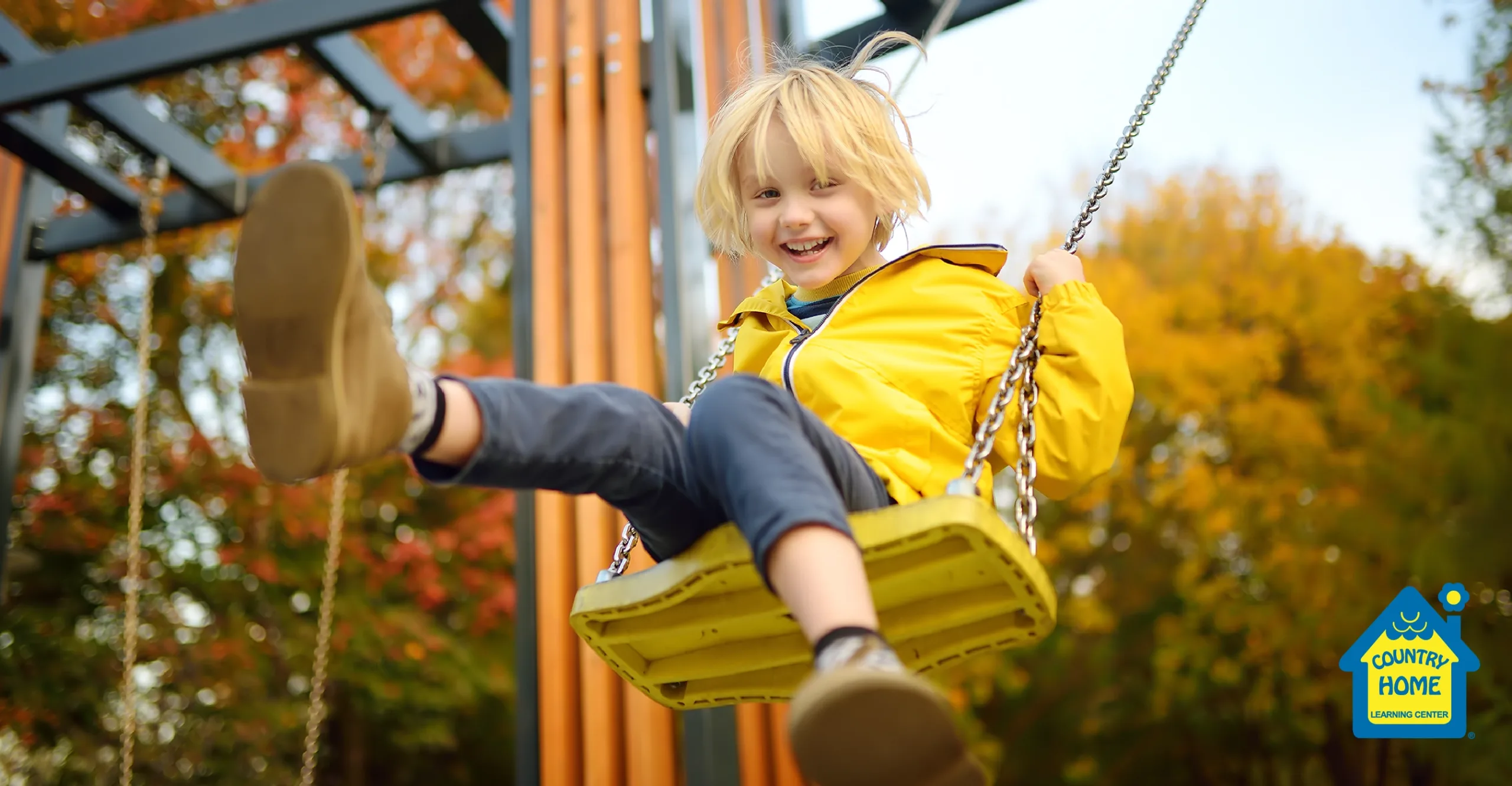 young boy swinging on a swing in the sunshine