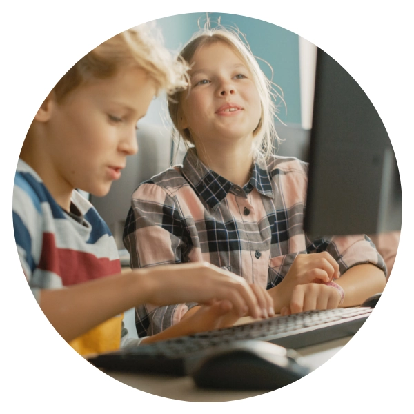 Two children use a computer for educational purposes.
