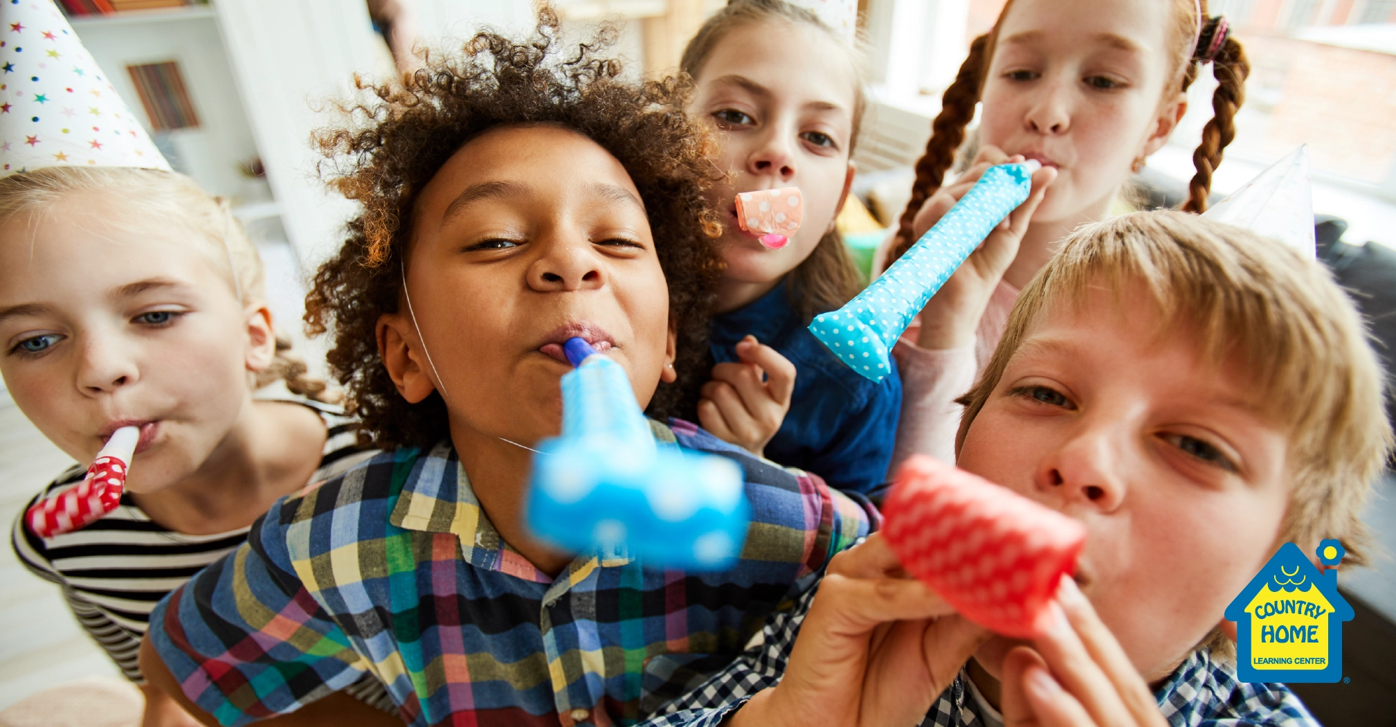 group of children blowing party horns at camera