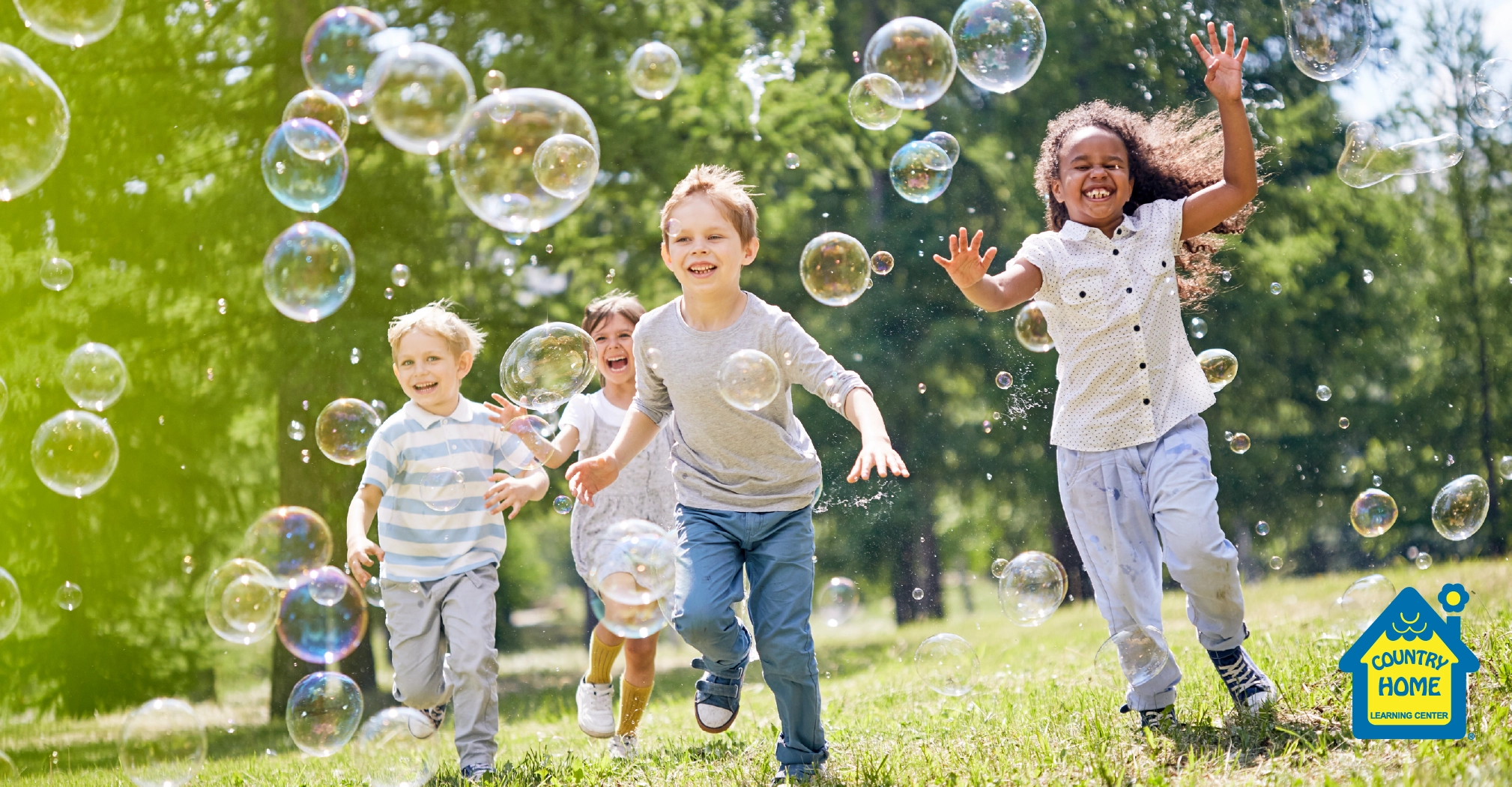 group of friends smile while enjoying warm sunny day and chasing bubbles