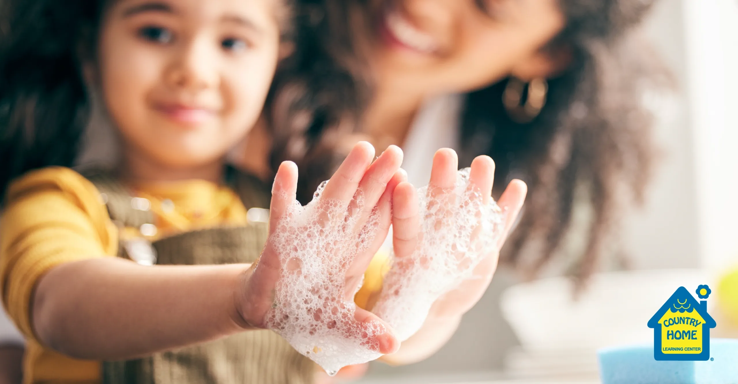 Young girl with soap on her hands from washing them