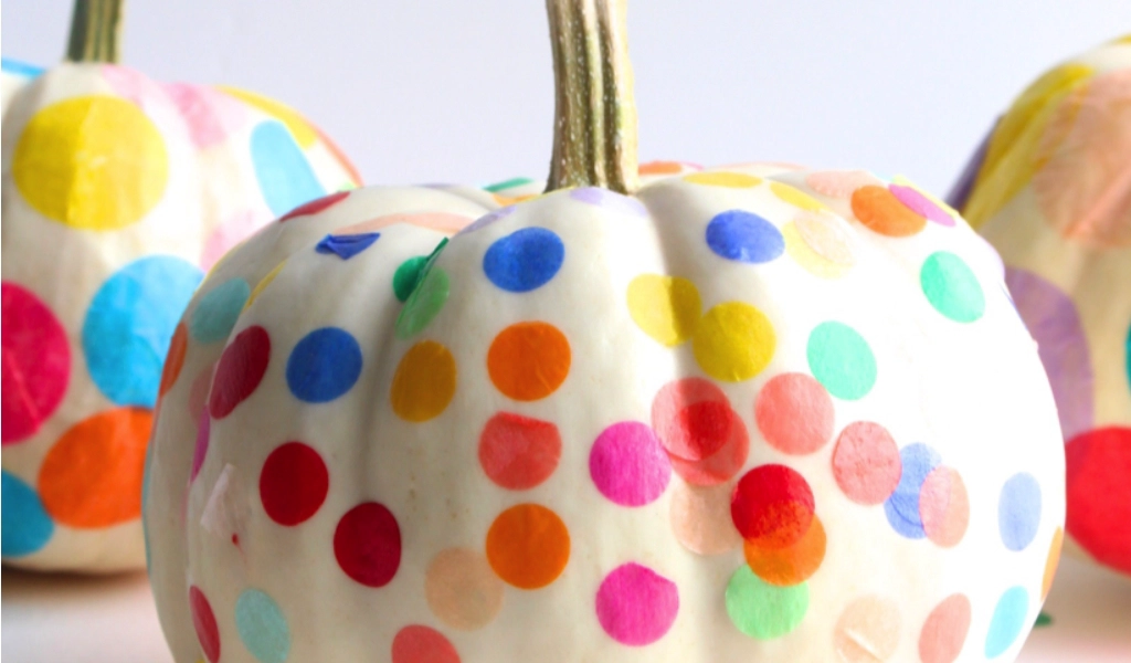 White pumpkins covered in colorful, round confetti dots, with a white background.