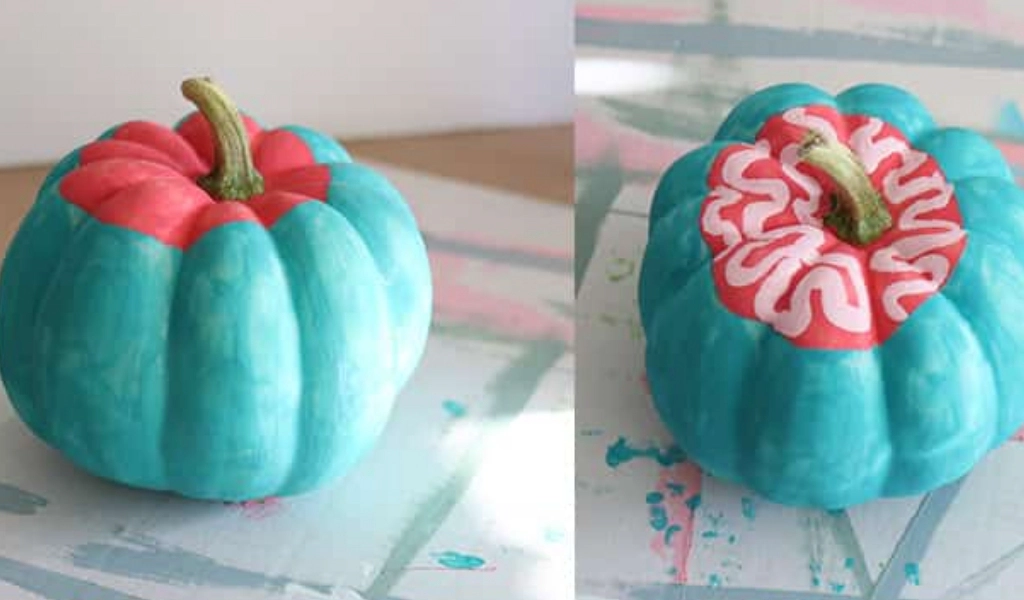 Two teal-painted pumpkins showing you step-by-step how to paint a zombie face