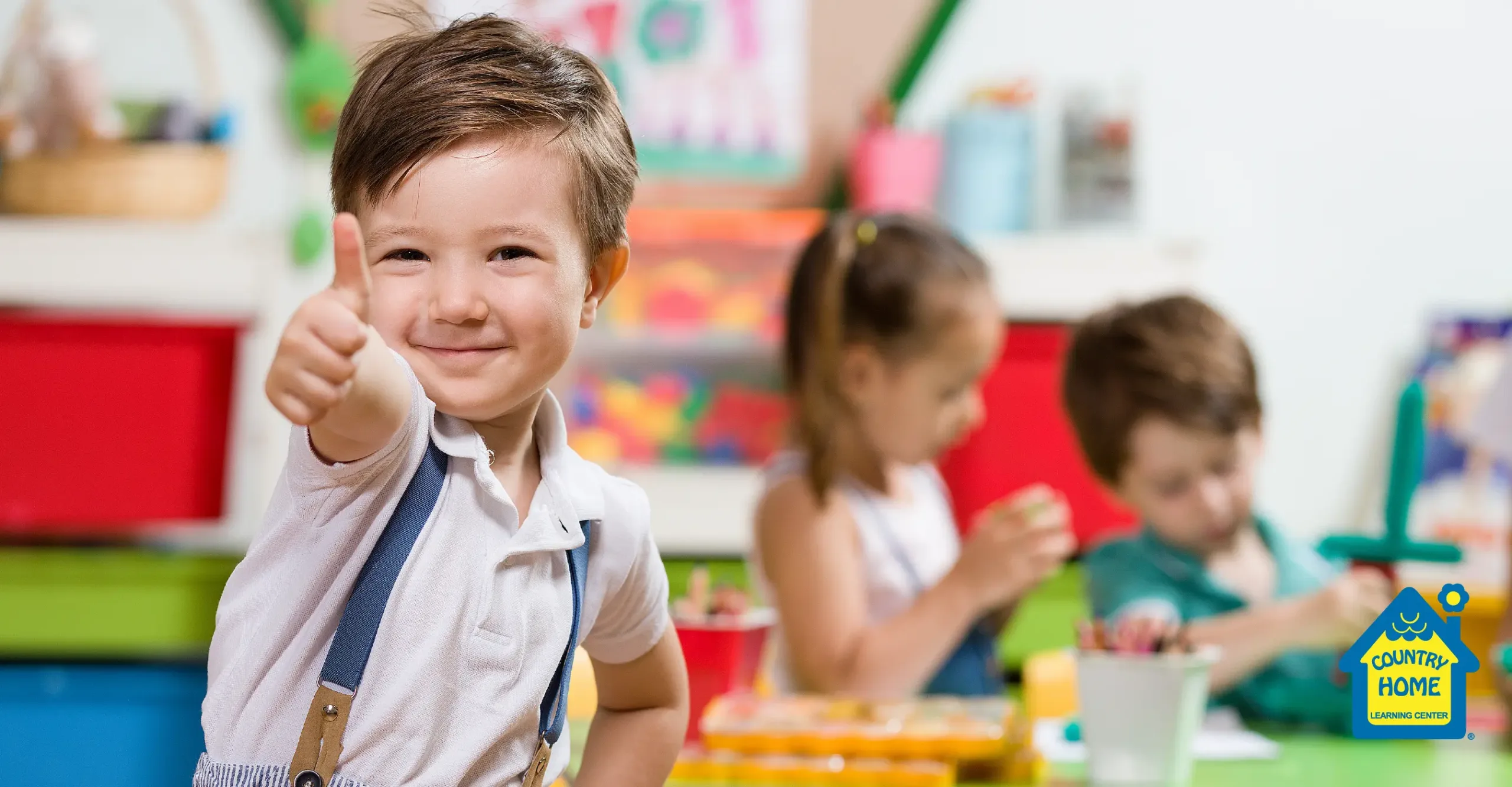 A smiling boy student gives a thumbs up to his parents' preschool choice.