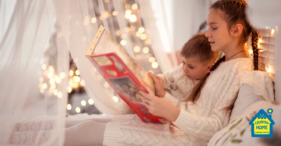 A girl reads a book to her younger brother.