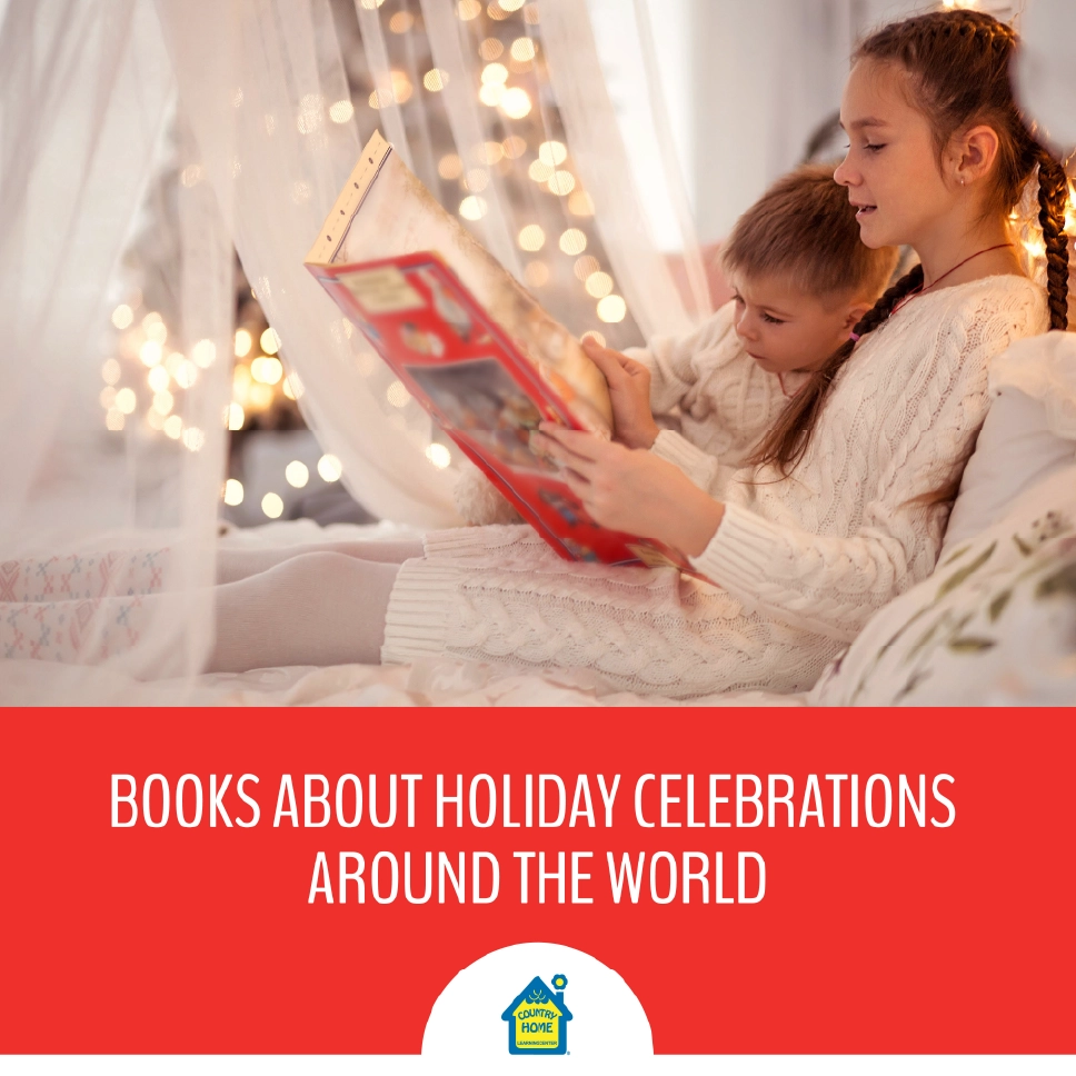 A girl reads a book to her younger brother, with Christmas lights in the background.