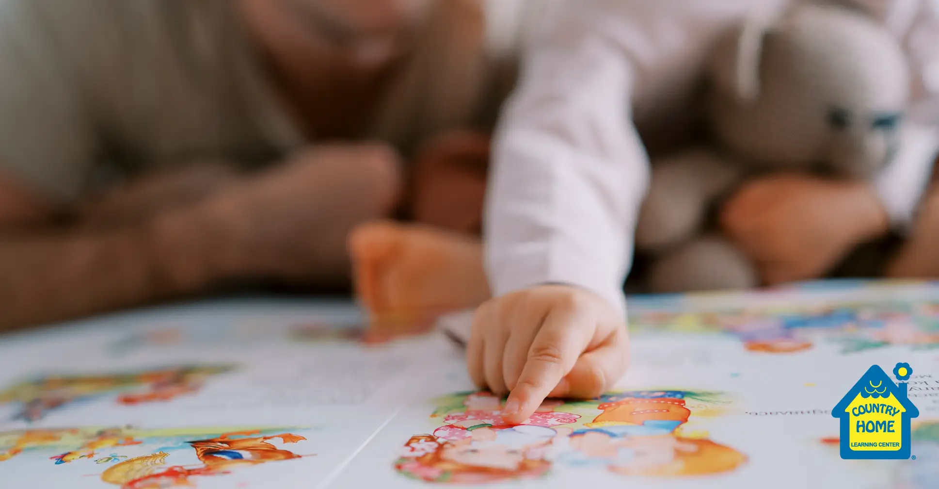 Little girl pointing to shapes in a book.