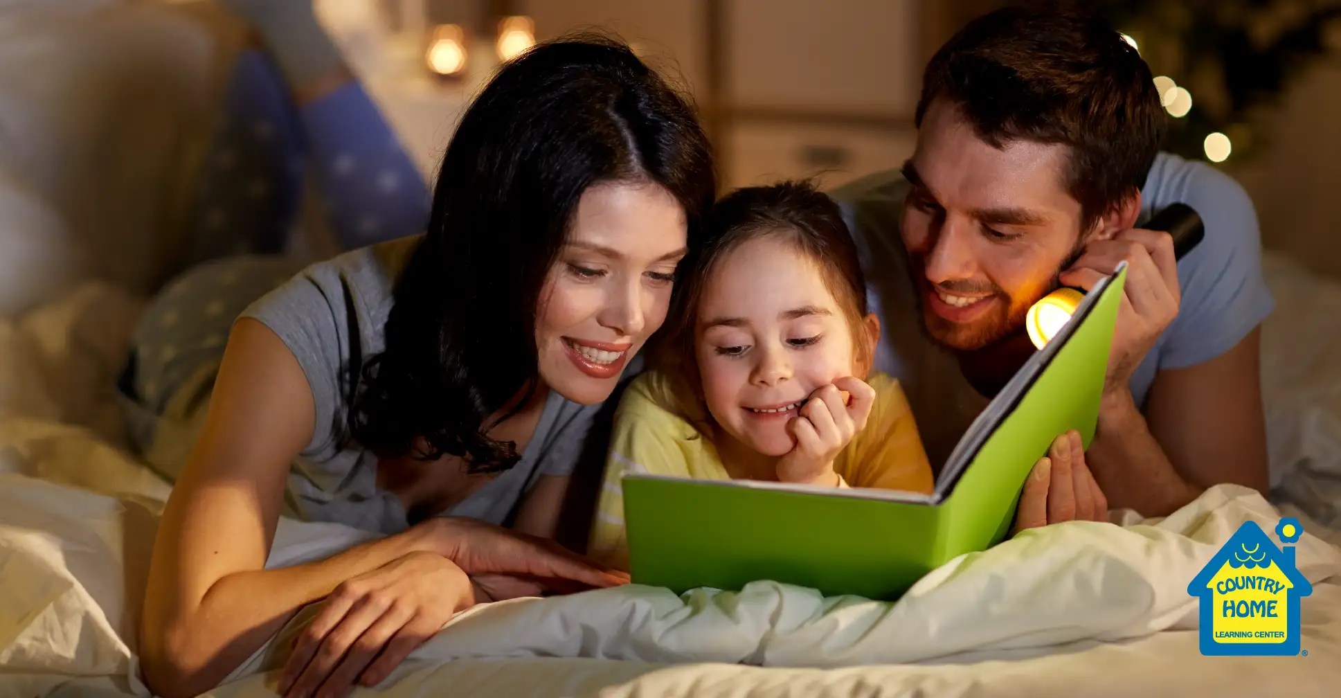 Mom and dad reading with daughter at night before bed.