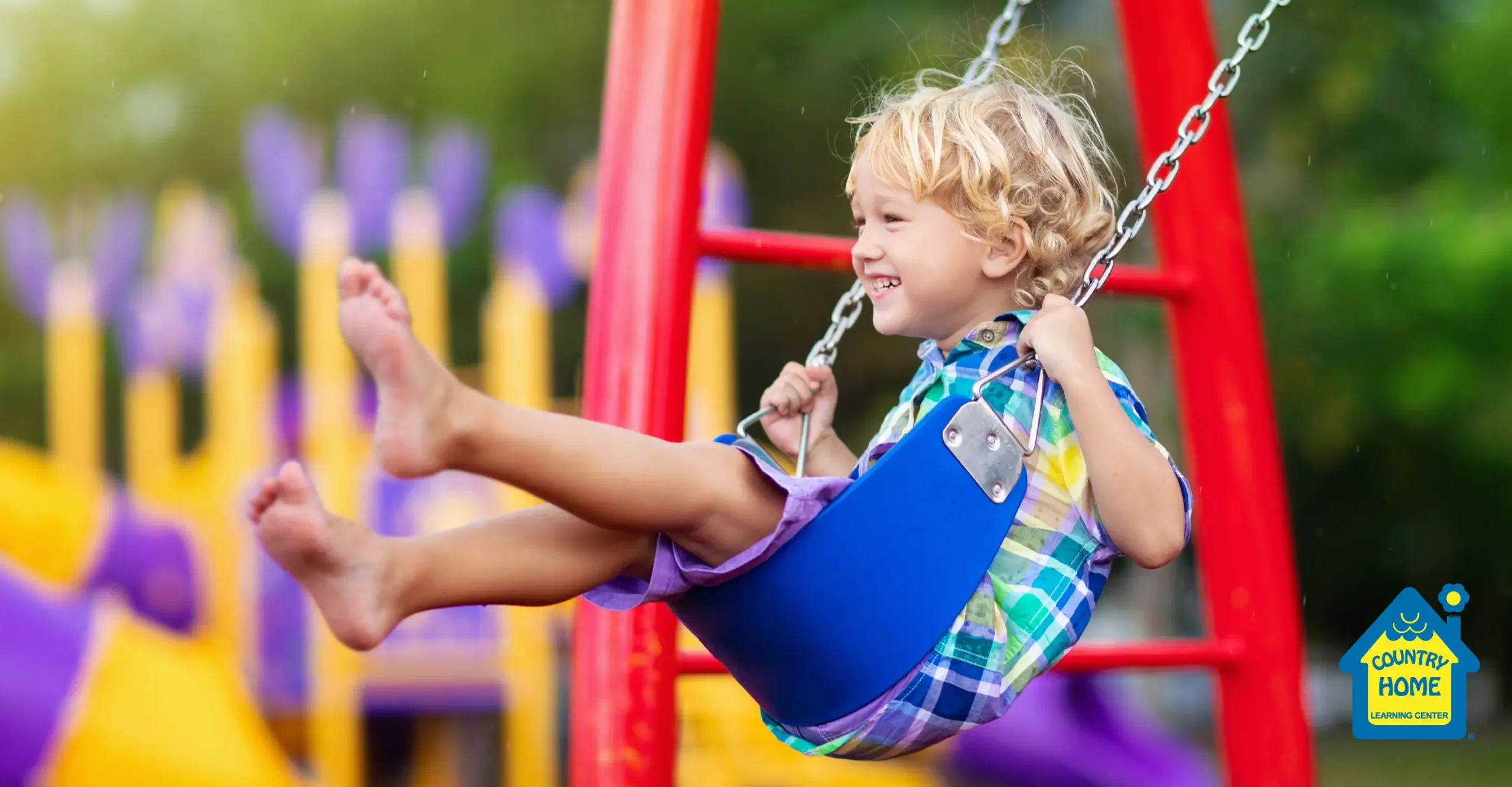 Preschooler playing outside, swinging on the swings.
